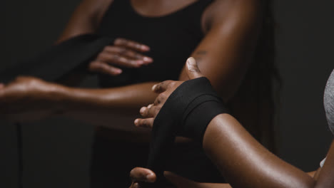 Studio-Shot-Of-Women-Putting-On-Boxing-Wraps-On-Hands-Before-Exercising-Together